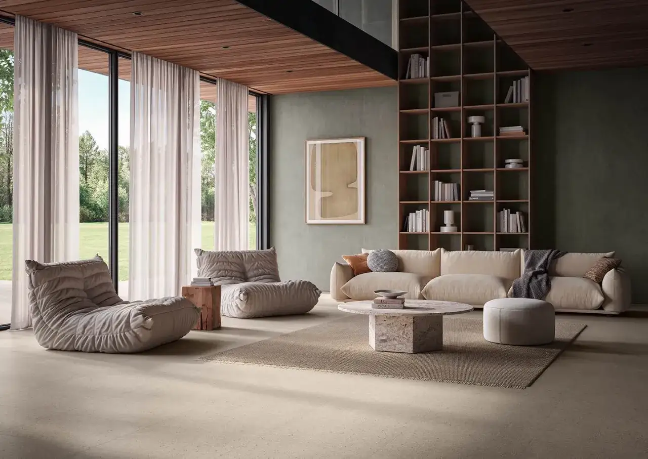 Sala de estar moderna con sofás, sillones y estanterías. El suelo de baldosas imita diferentes tipos de suelo, aportando calidez y textura.